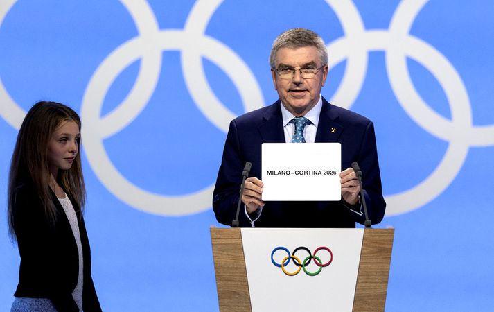 Thomas Bach, forseti Alþjóðaólympíunefndarinnar, sýnir hér hvar Vetrarólympíuleikarnir 2026 fara fram.