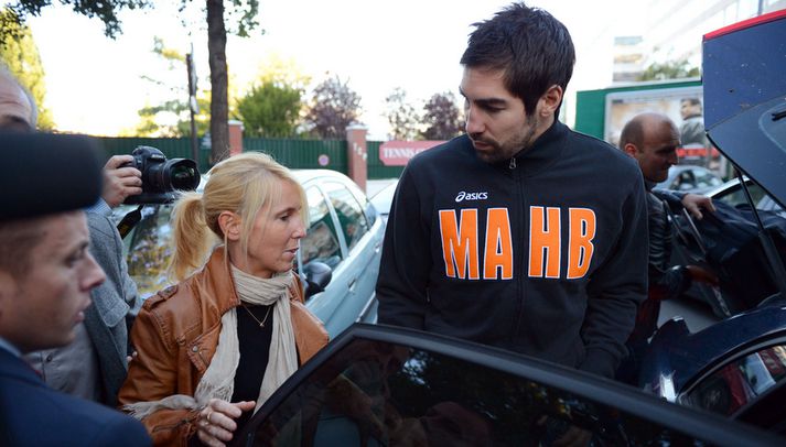 Karabatic er hér leiddur út í lögreglubíl eftir leikinn í dag.